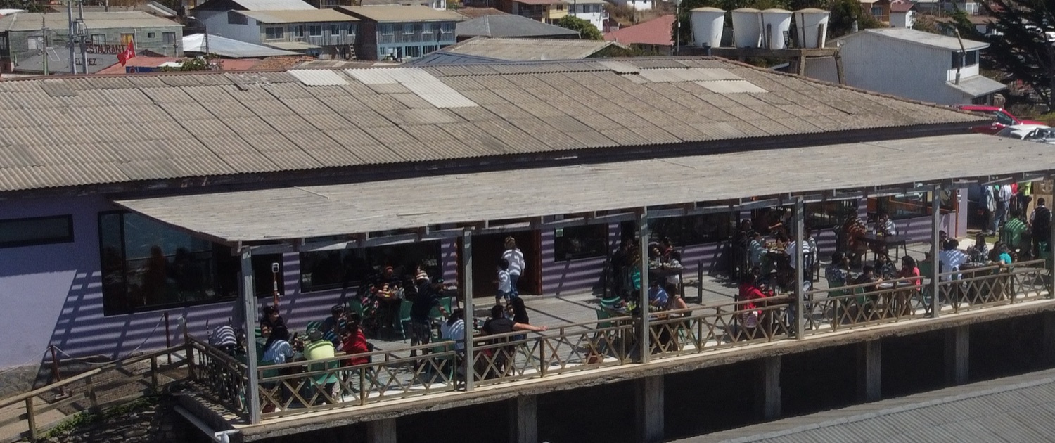 Comensales almorzando en la terraza del restaurant con vista al océano Pacífico